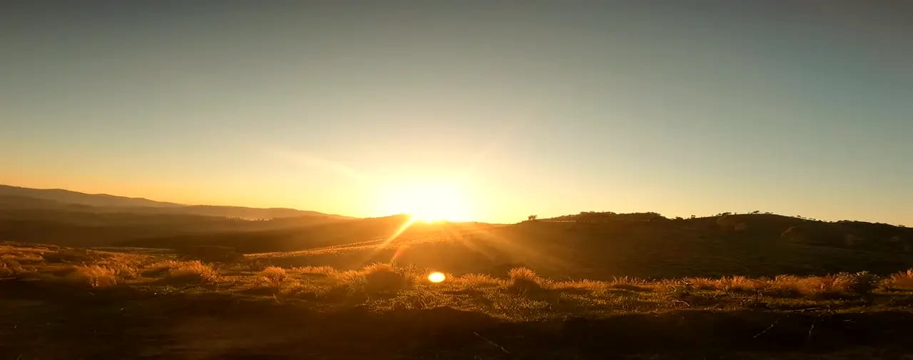 O sol estourando rasante na crista, incendiando o capim dourado